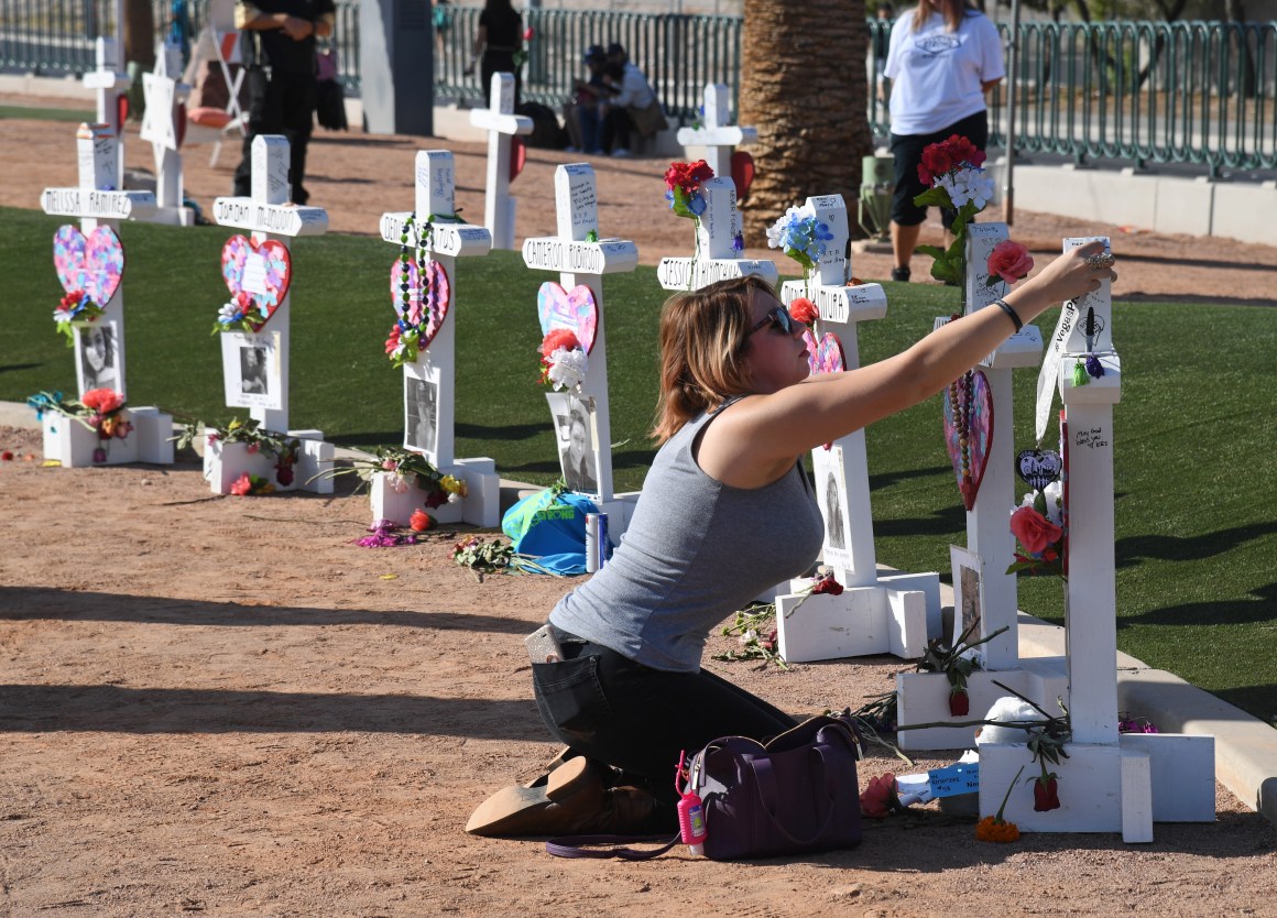 Ashley Schuck of Nevada places a medal from Saturday's Vegas Strong 5k on a cross set up for shooting victim Neysa Tonks on October 1st, 2018, in Las Vegas, Nevada. Retired carpenter Greg Zanis, who installed 58 crosses last year—one for each person killed—set up the memorial again with new crosses for the massacre's anniversary. On October 1st, 2017, Stephen Paddock opened fire on the Route 91 Harvest Country Music Festival, killing 58 people and injuring more than 800 in the deadliest mass shooting event in modern United States history.