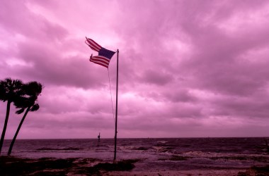 An American flag battered by Hurricane Michael waves against a rose-colored light of sunset at Shell Point Beach on October 10th, 2018, in Crawfordville, Florida.