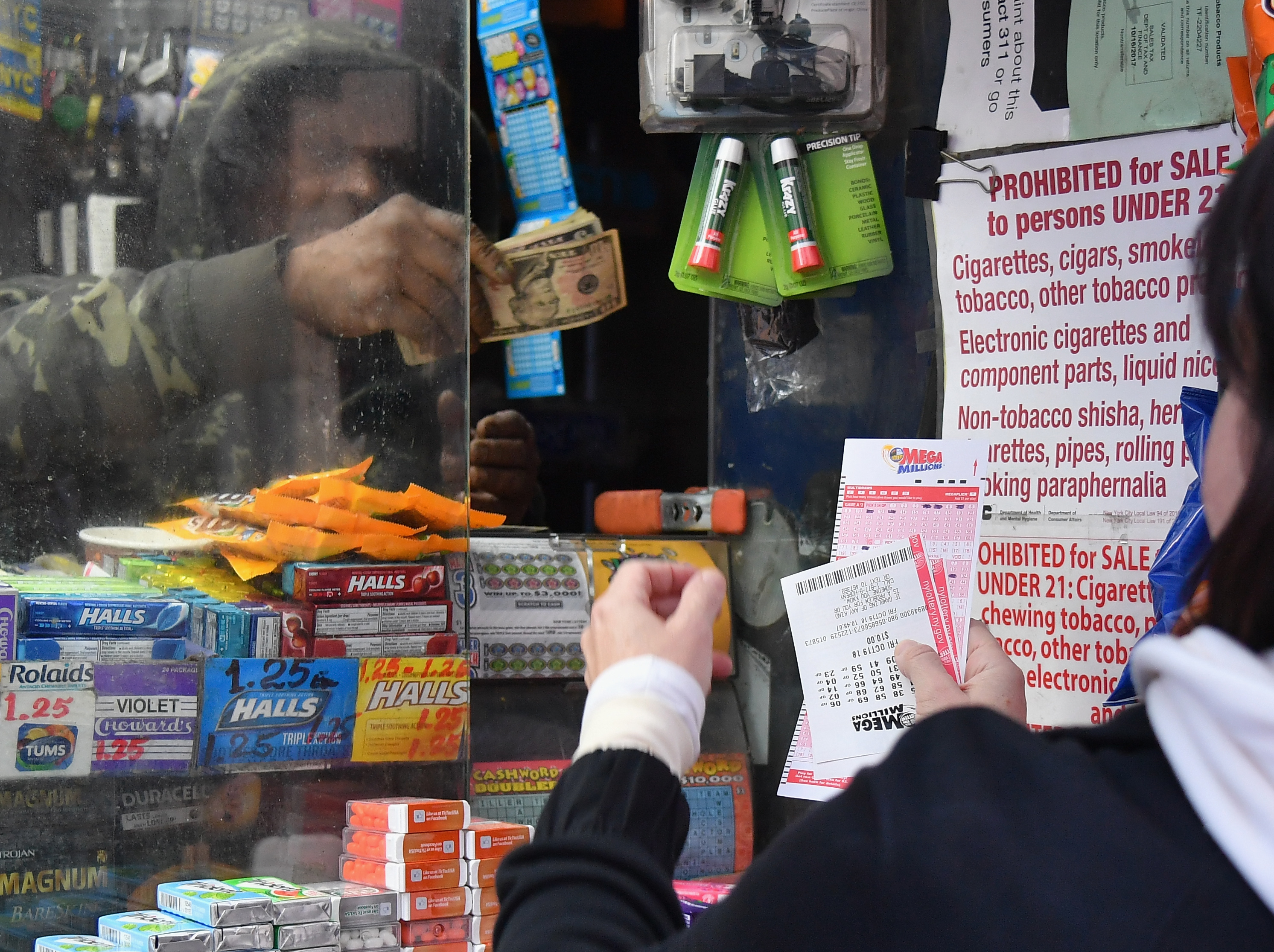 A woman purchases Mega Millions lottery tickets on October 19th, 2018, in New York City. The Mega Millions jackpot is currently up to 0 million.