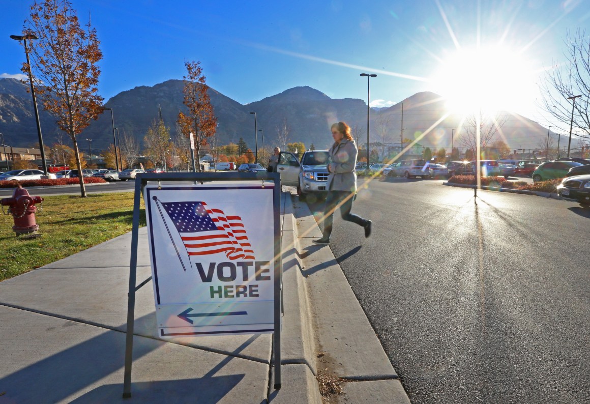 A woman walks into a polling center to vote in the mid-term elections as the morning sun rises over the Utah Wasatch Mountains on November 6th, 2018, in Provo, Utah.