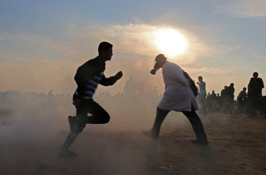 Palestinians run for cover from tear gas during clashes near the border between Israel and Khan Yunis in the southern Gaza Strip on November 9th, 2018.