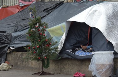 A Venezuelan migrant rests next to a Christmas tree at an improvised camp near a bus terminal in Bogota, Colombia, on November 9th, 2018.