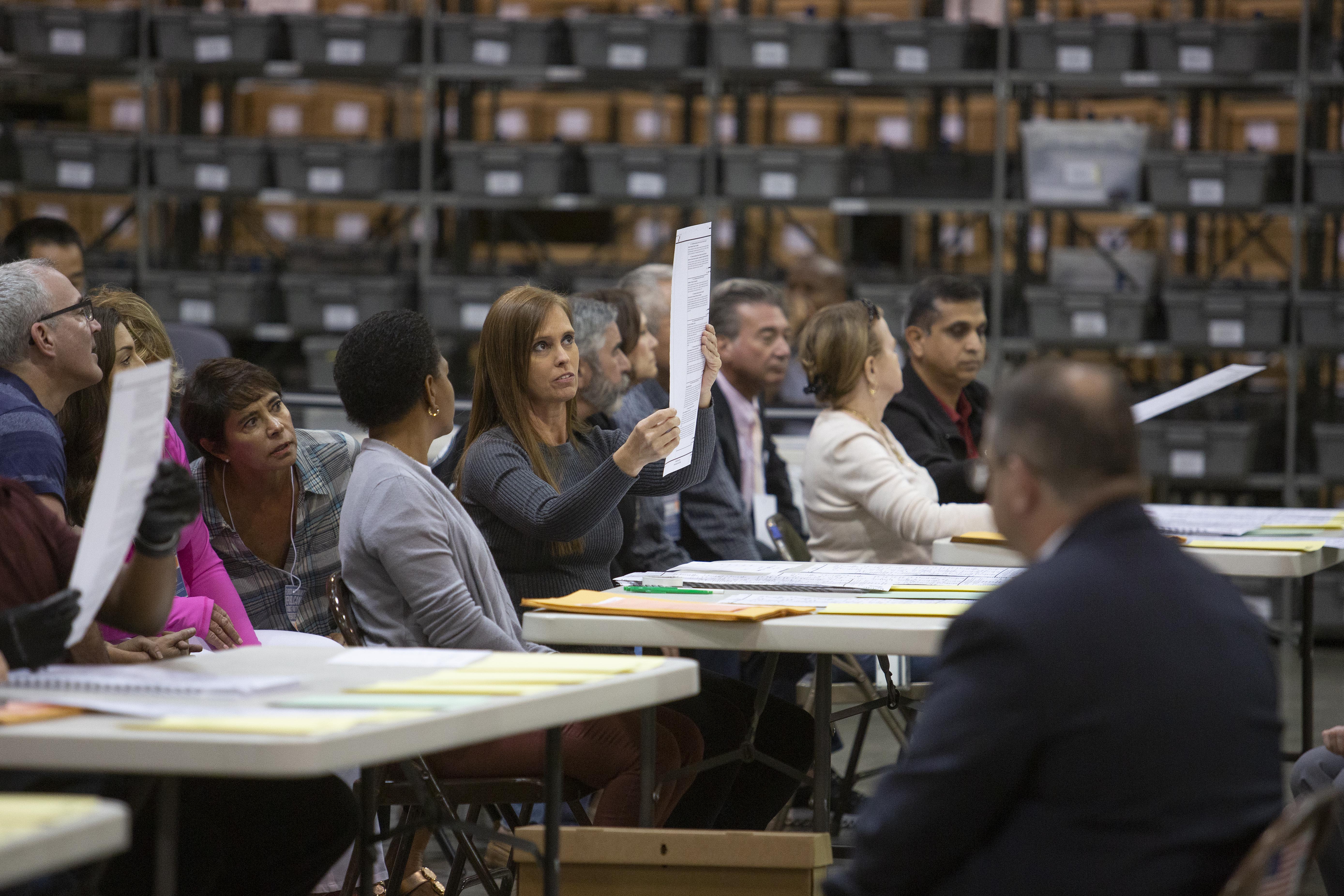 Volunteers look at ballots during a hand recount at the Supervisor of Elections Service Center on November 16th, 2018, in Palm Beach, Florida. After missing a deadline to recount votes for governor, a hand recount has been ordered for the Senate and agriculture commissioner's races.