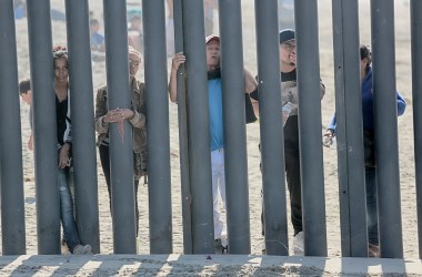 Honduran caravan members look through the fence at the United States–Mexico border wall at Friendship Park in San Ysidro, California, on November 18th, 2018.