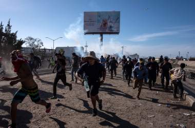 Central American migrants (mostly Hondurans) run along the Tijuana River near the El Chaparral border crossing in Tijuana, Baja California State, Mexico, near the U.S.–Mexico border, after the U.S. border patrol threw tear gas to disperse them after an alleged verbal dispute, on November 25th, 2018.