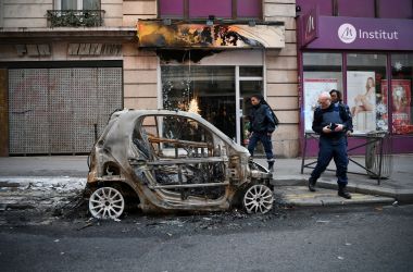 Police look at a burnt car in Paris, France, on December 9th, 2018—one day after "yellow vest" protests rocked the country. More than 1,700 people were arrested across France during the latest "yellow vest" protests against rising living costs.