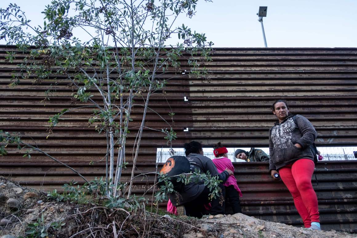 Honduran migrants look through the U.S.-Mexico border fence in Tijuana, Mexico on December 15th, 2018. Former Attorney Jeff Sessions issued an interim decision in June in which he ruled that the violence survivors did not merit asylum.