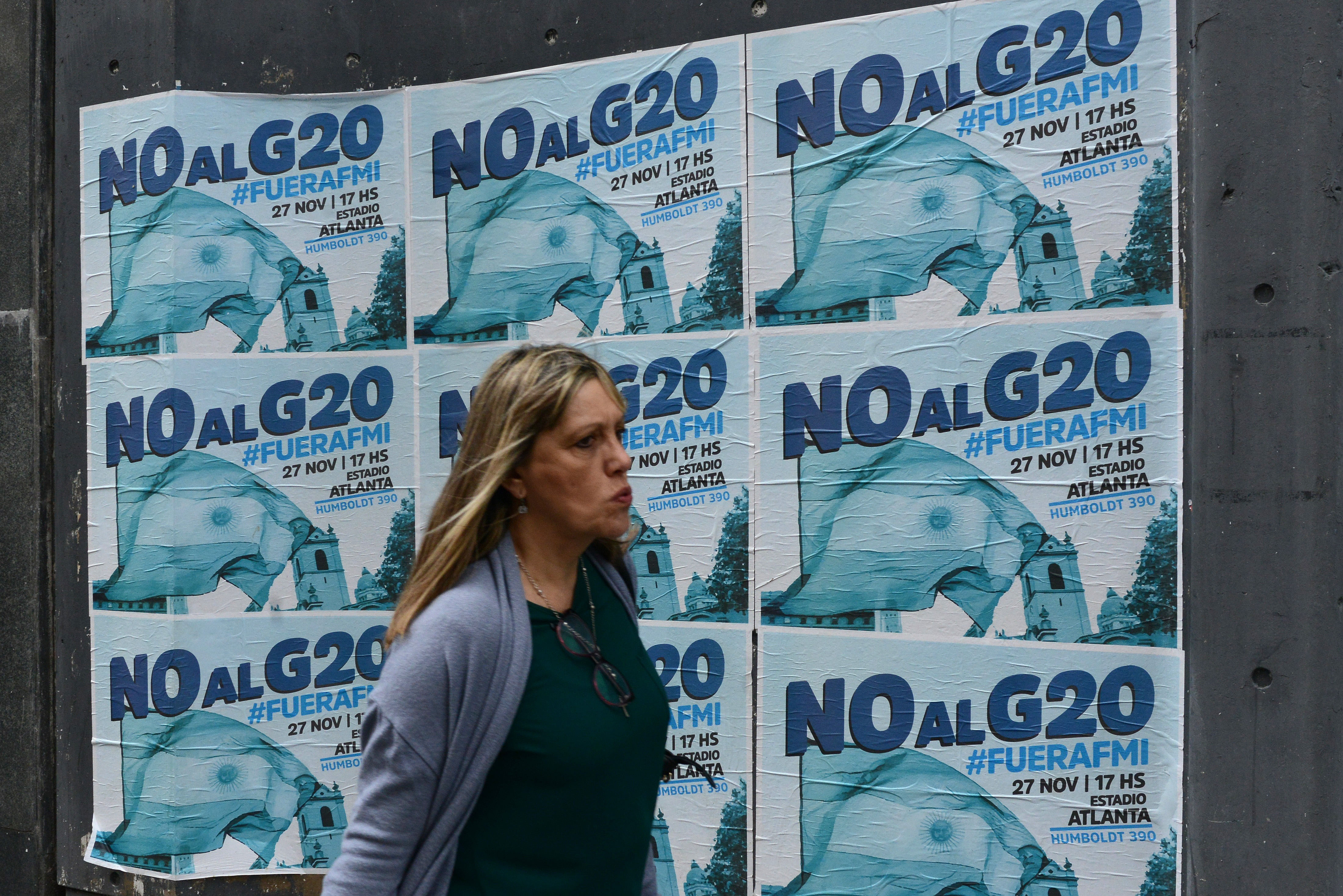 A woman walks past banners against G20 and the International Monetary Fund on the day before the beginning of the G20 Leaders' Summit 2018 on November 29th, 2018, in Buenos Aires, Argentina. Over 24,000 police officers and security agents work on the G20, which gathers the leaders of the top 20 industrialized nations of the world during a two-day meeting on November 30th and December 1st.