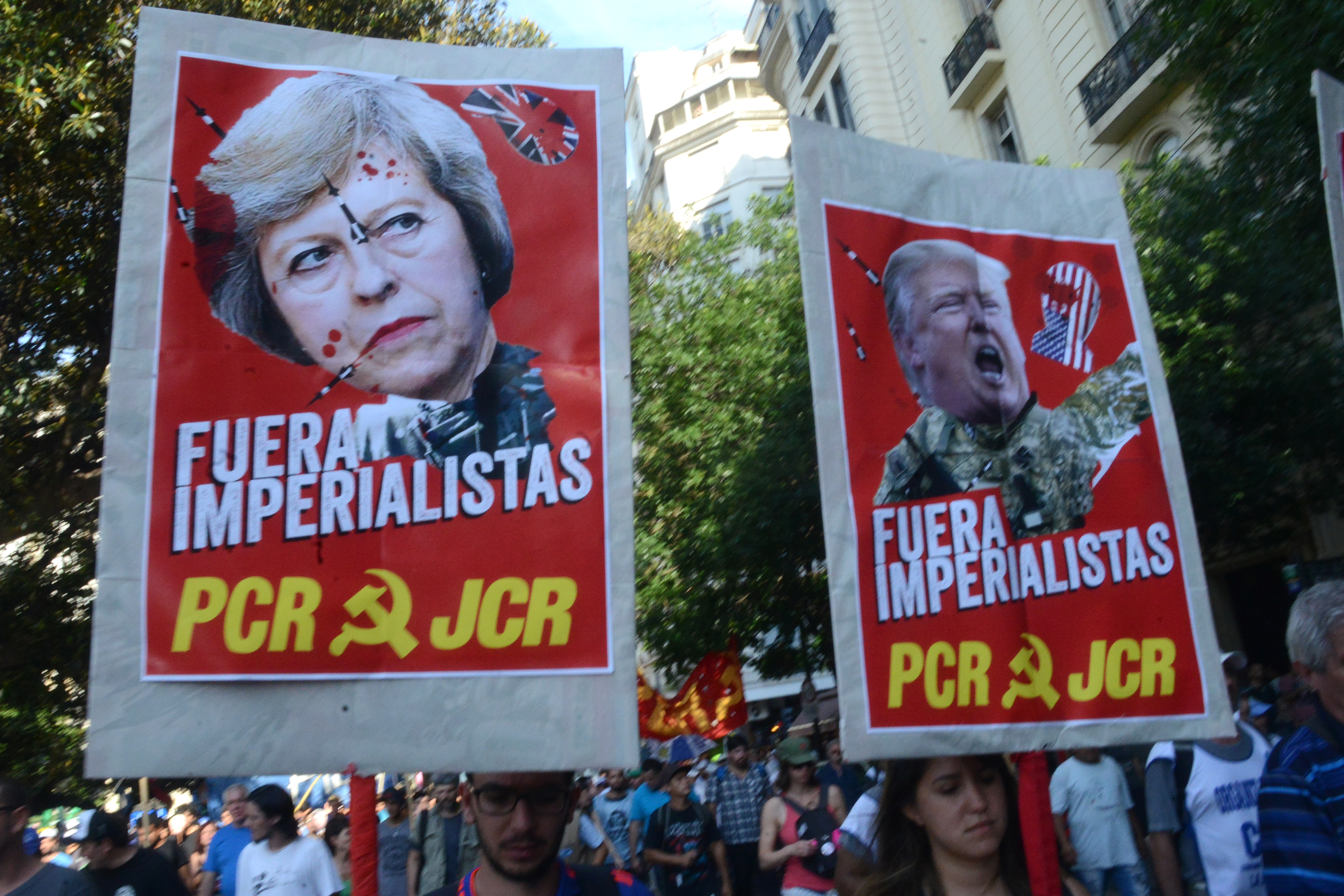 Communist demonstrators hold up posters decrying United Kingdom Prime Minister Theresa May and U.S. President Donald Trump as imperialists in Spanish in Buenos Aires on November 30th, 2018.