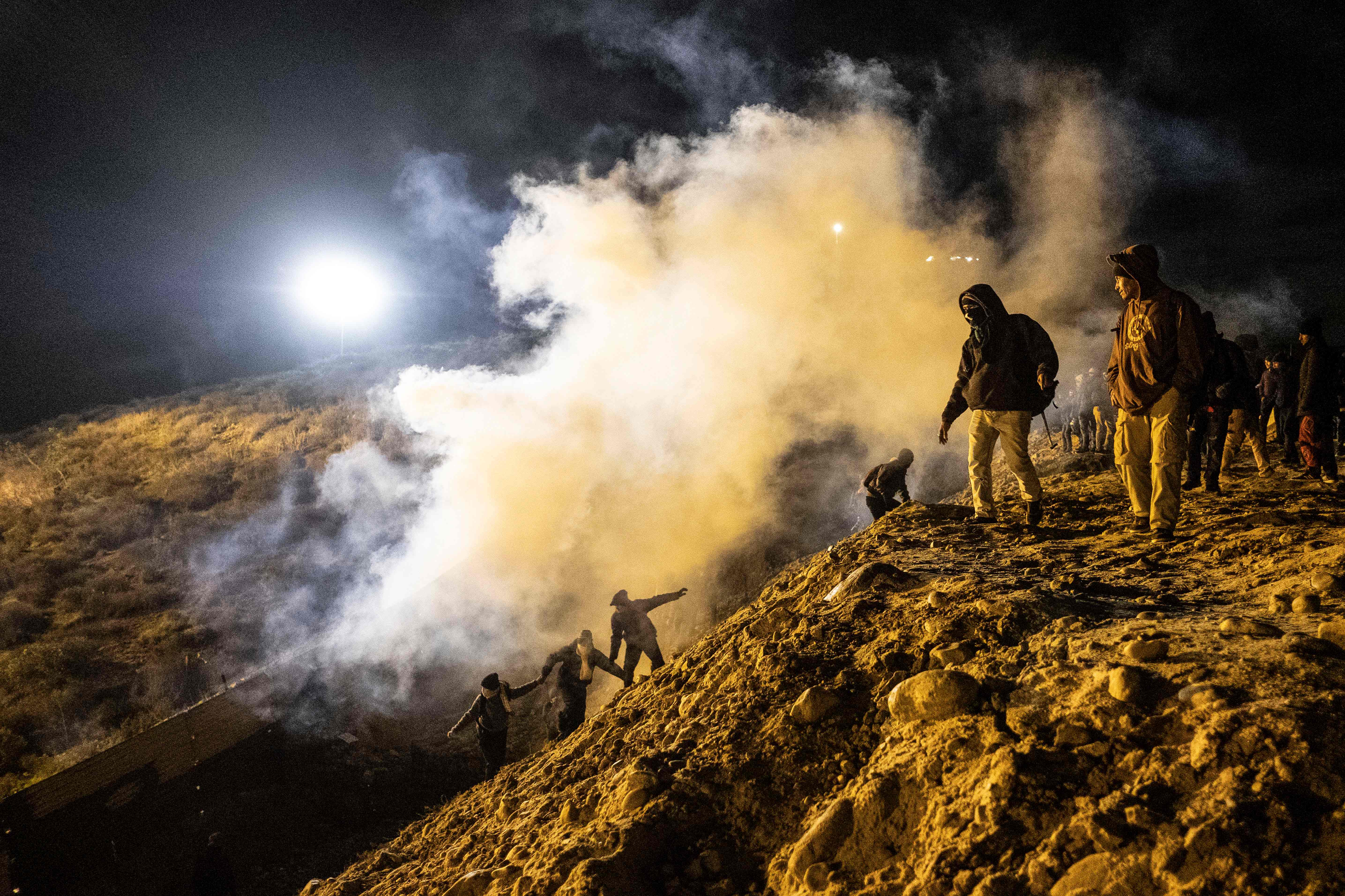 Central American migrants run away from tear gas after they try to cross from Tijuana into California on January 1st, 2019.