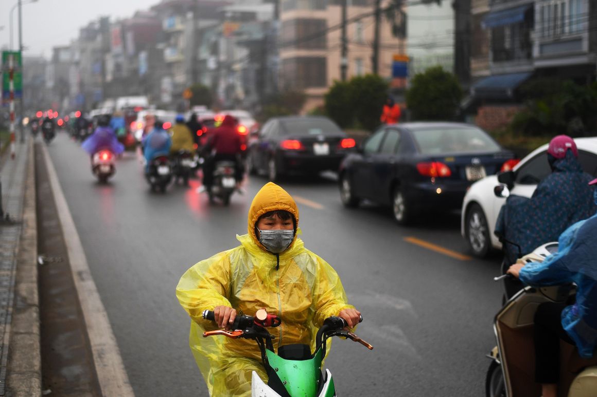 A young boy rides his electric scooter in the rain in Hanoi, Vietnam, on January 7th, 2019.