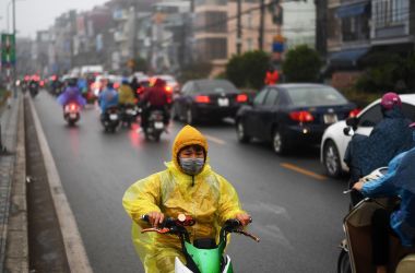 A young boy rides his electric scooter in the rain in Hanoi, Vietnam, on January 7th, 2019.