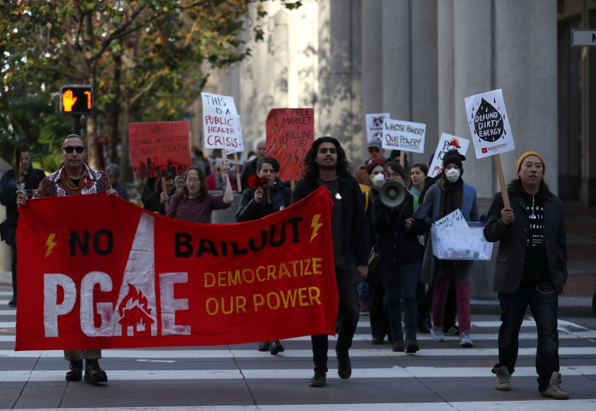 Protesters hold signs as they march to the Pacific Gas and Electric headquarters in San Francisco, California, on December 11th, 2018.