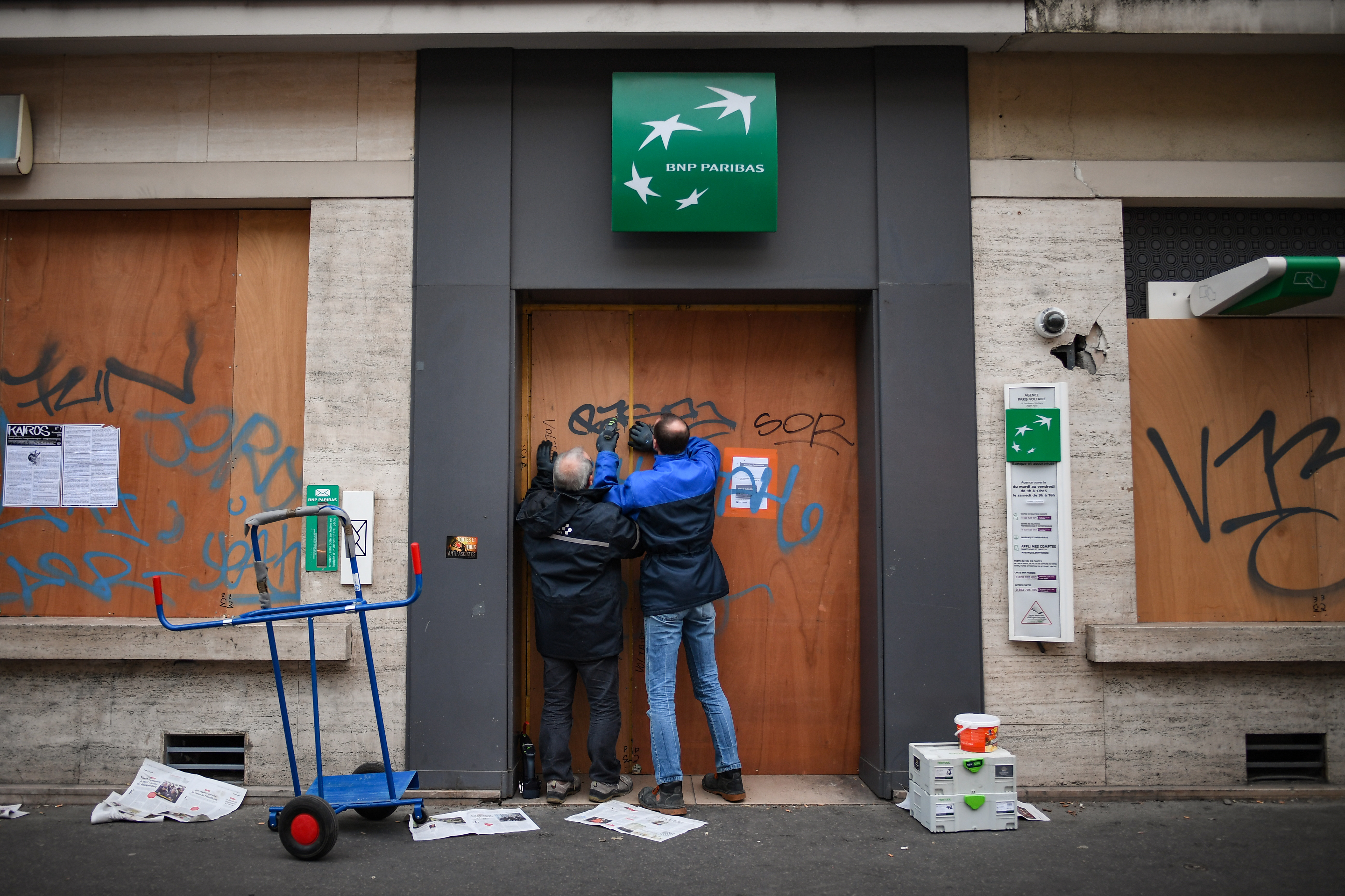 People board up shops near Place de Republique ahead of Saturday's 