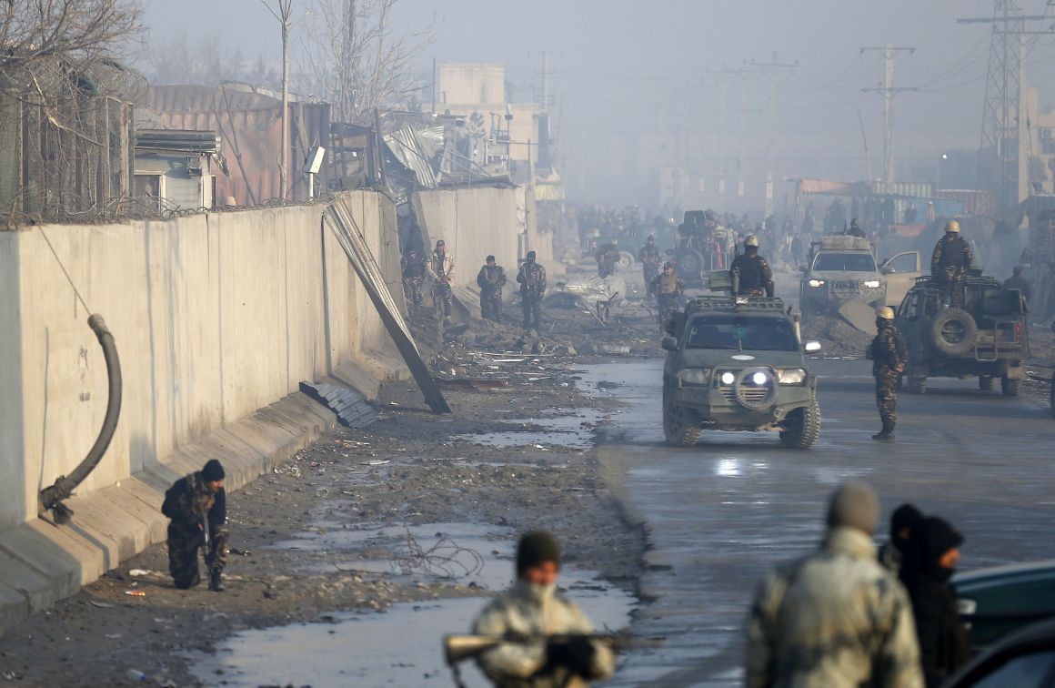 Afghan security forces gather in mid-January at the site of a powerful truck bomb attack, claimed by the Taliban, which killed four and wounded over 100.