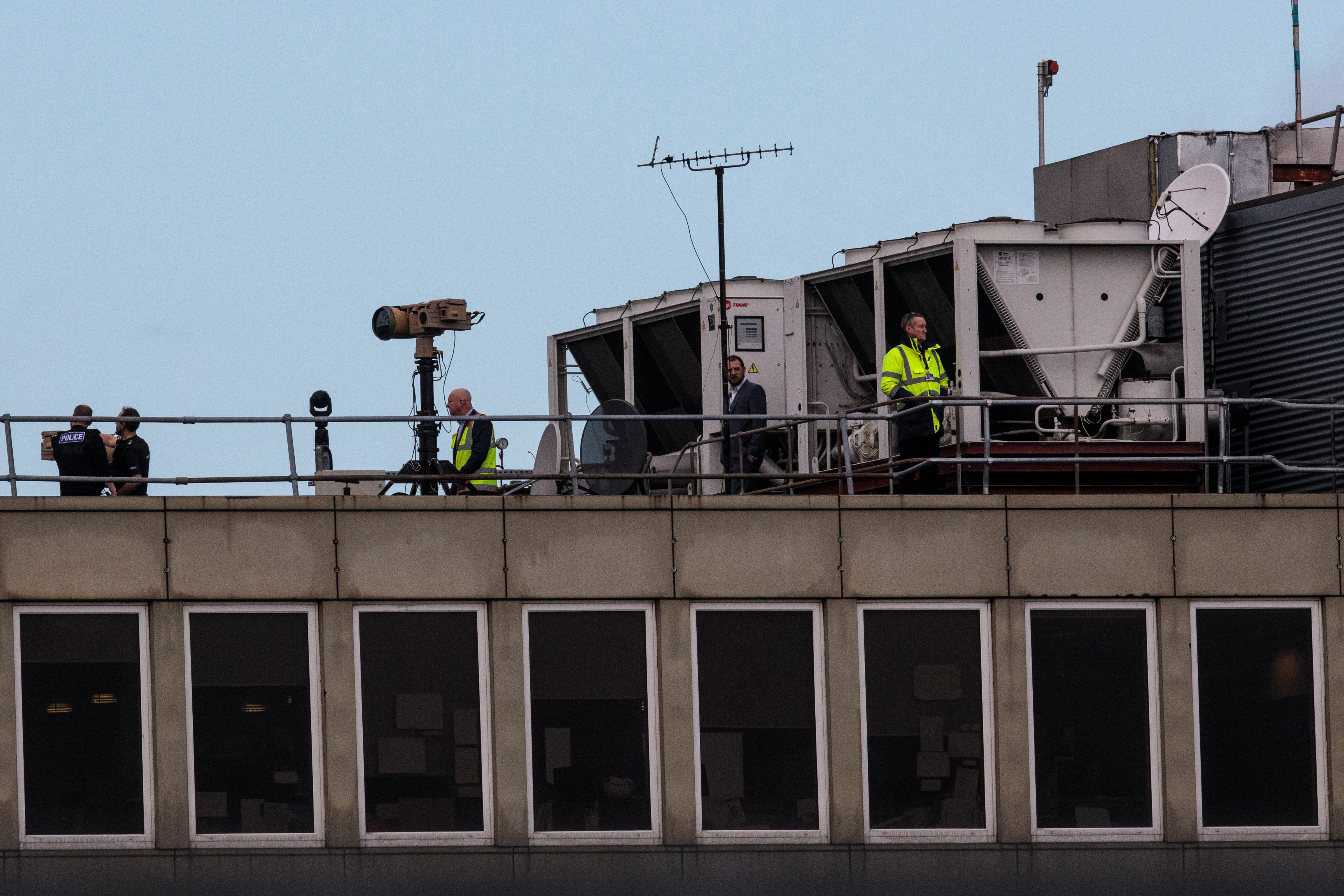 Officials stand near equipment and survey the runway at Gatwick Airport on December 21st, 2018.