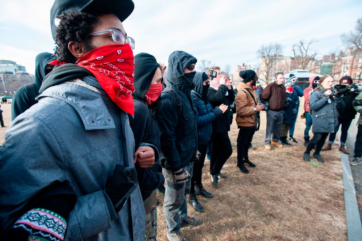 Anti-fascist counter-protesters form a circle around the helmeted members of a right-wing group during the Women's March at Boston Common in Boston, Massachusetts, on January 19th, 2019.