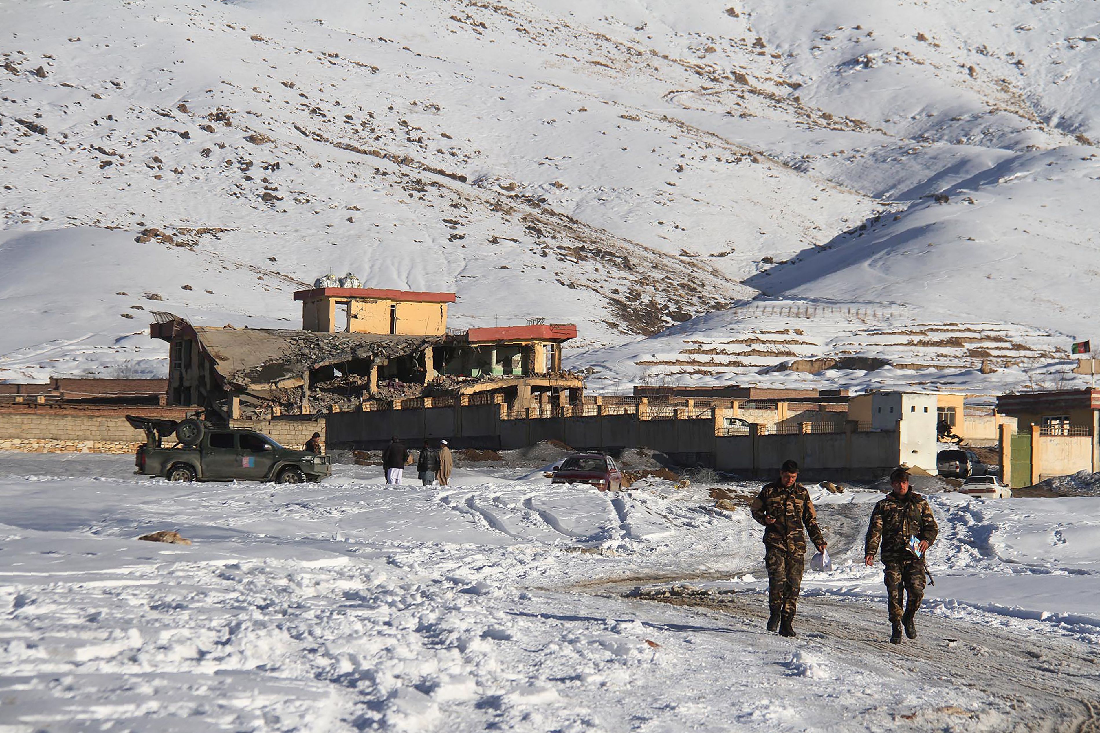 Afghan security forces walk near the attack site after a car bomb detonated on a military base in Wardak Province on January 21st, 2019.