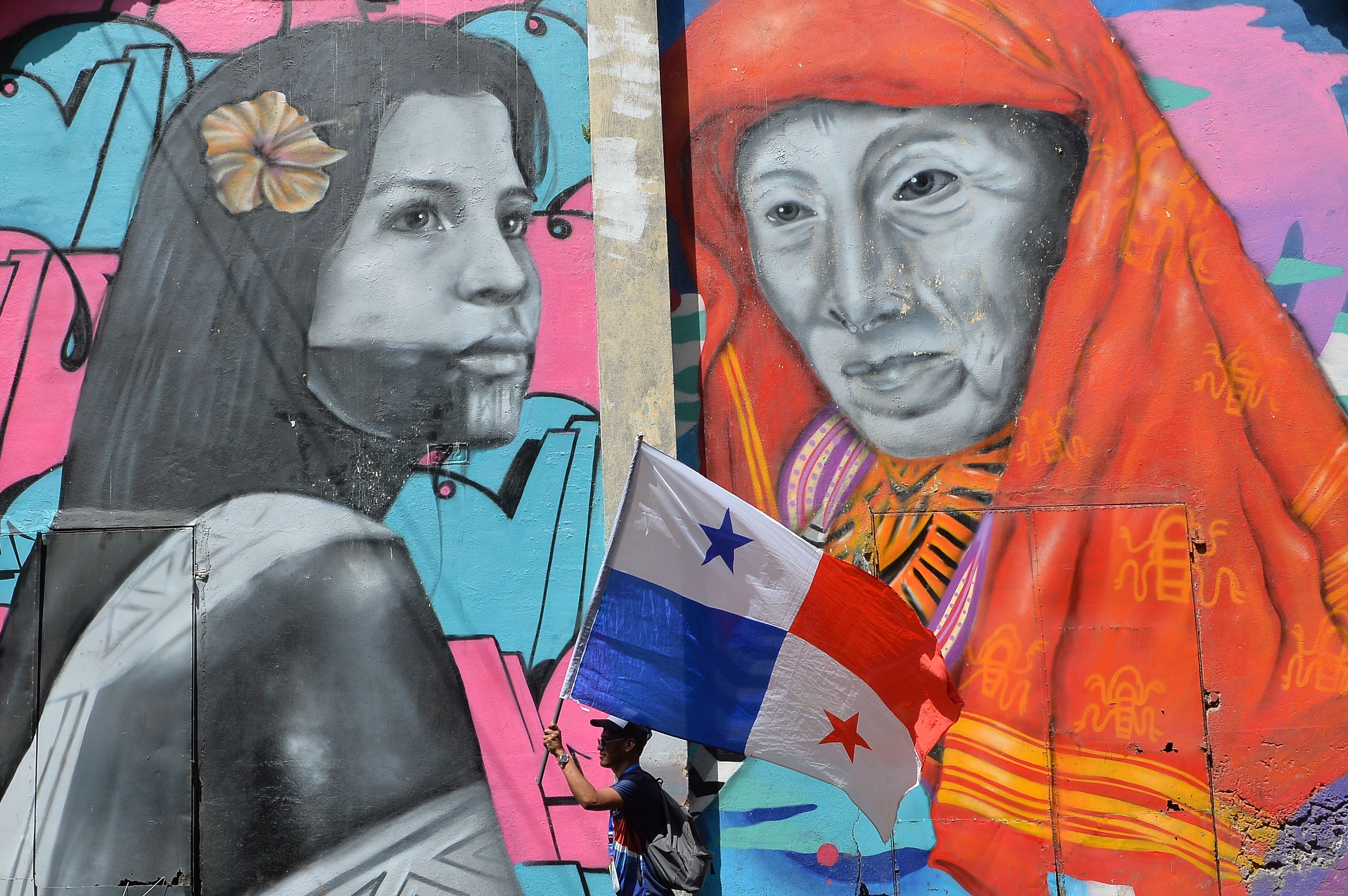 A pilgrim carries a Panamanian flag as he walks through the streets of Panama City during World Youth Day on January 24th, 2019.