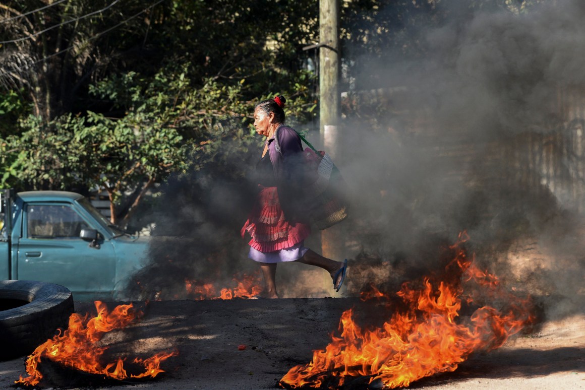 A woman walks through a roadblock mounted by supporters of the LIBRE opposition party in the El Carrizal neighborhood of Tegucigalpa, Honduras, on January 27th, 2019. The opposition is demanding that President Juan Orlando Hernández step down, a year after the start of his second term.