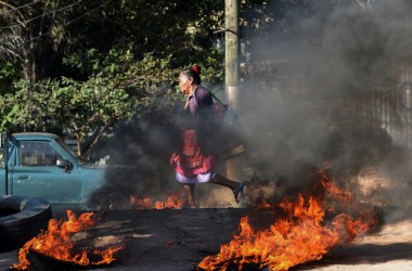 A woman walks through a roadblock mounted by supporters of the LIBRE opposition party in the El Carrizal neighborhood of Tegucigalpa, Honduras, on January 27th, 2019. The opposition is demanding that President Juan Orlando Hernández step down, a year after the start of his second term.