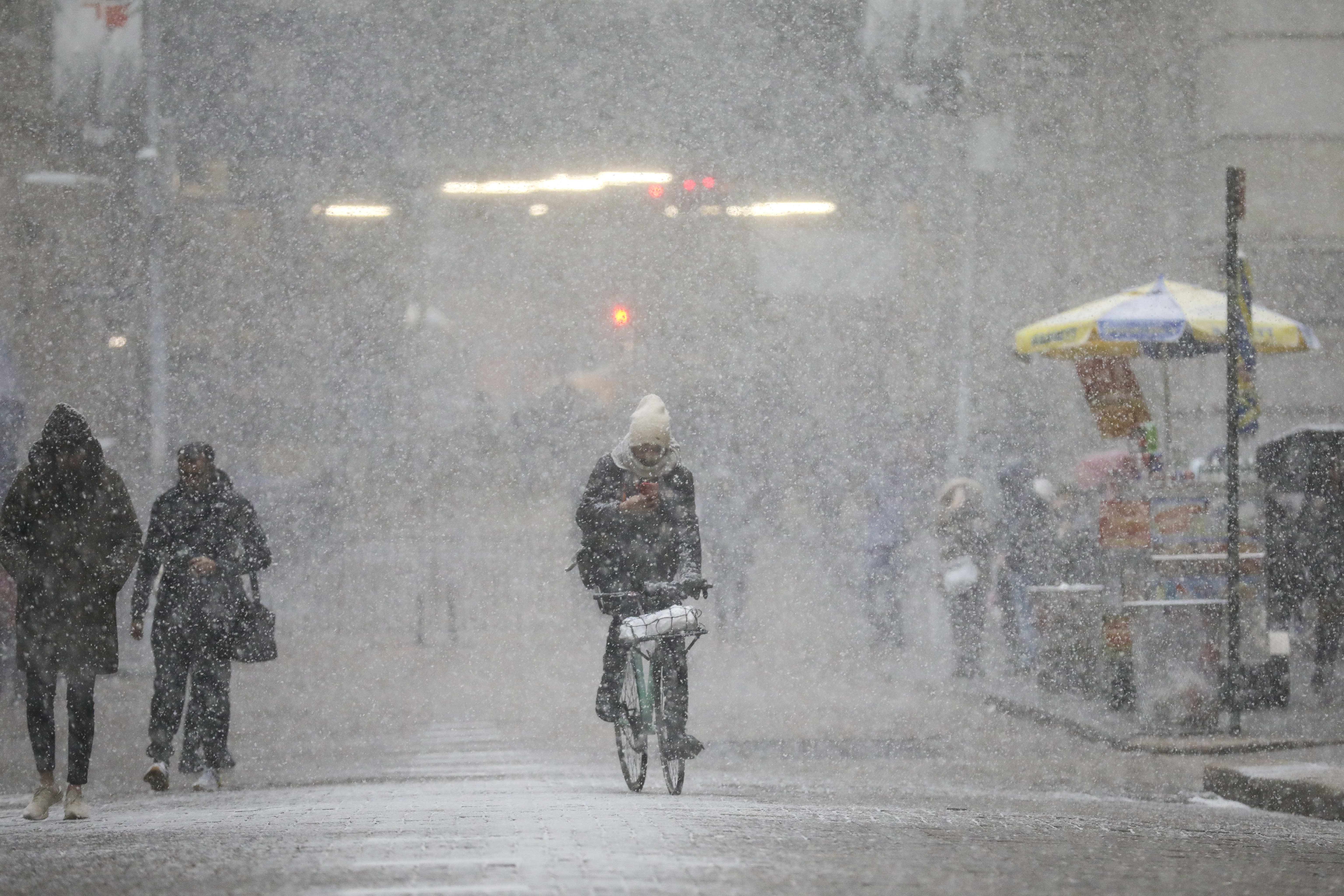 A cyclist rides through the falling snow in the Financial District, January 30th, 2019, in New York City.