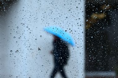 Raindrops are seen on a vehicle window as a pedestrian walks in the rain in Los Angeles, California on January 31st, 2019, as heavy rains hit southern California bringing thunder and lightning.