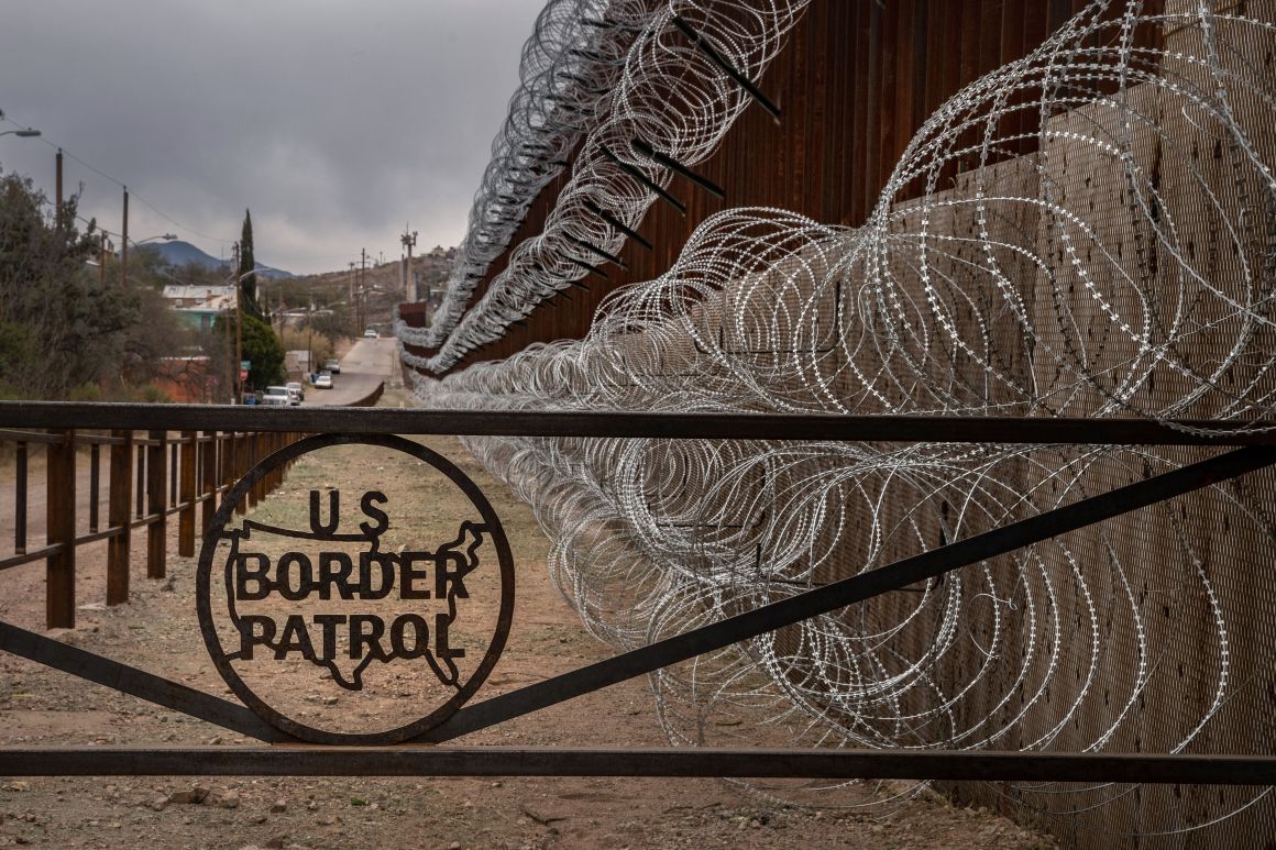 A metal fence marked with the U.S. Border Patrol sign prevents people from getting close to the barbed/concertina wire covering the U.S.–Mexico border fence, in Nogales, Arizona, on February 9th, 2019.