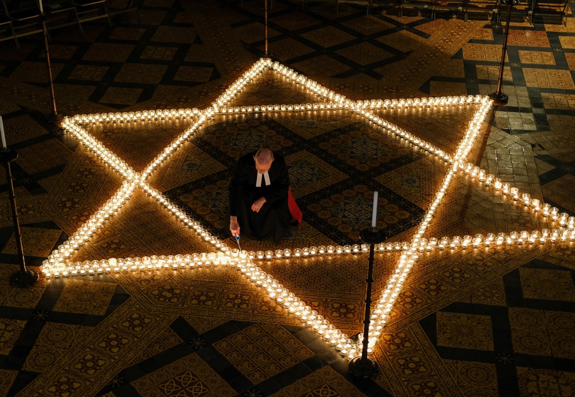 The Reverend Canon Dr. Chris Collingwood, York Minster's Canon Chancellor, lights some of the 600 candles in the form of the Star of David set out on the floor during an event to commemorate Holocaust Memorial Day in the Chapter House at York Minster on January 24th, 2019, in York, England. The ceremony in the minster is one of many international events for Holocaust Memorial Day, held on January 27th. This date marks the liberation of the Auschwitz-Birkenau concentration camp in 1945. The international theme for Holocaust Memorial Day 2019 is "Torn From Home," which encourages people to reflect on how the enforced loss of a safe place to call home is part of the trauma faced by anyone experiencing persecution and genocide. This year also marks the 25th anniversary of the Rwandan genocide, which began in April of 1994, and the 40th anniversary of the end of the Cambodian genocide, which ended in 1979.