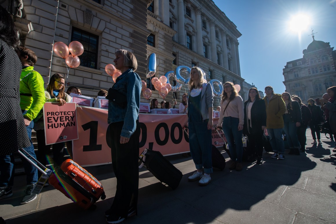 Amnesty International protesters (front) call for a change in Northern Irish abortion law as they walk past a counter demonstration at Parliament Square on February 26th, 2019, in London, England. Northern Ireland is currently the only country in the United Kingdom where it is illegal to have an abortion. Each protester with Amnesty International carried a suitcase containing sheets of paper with the names of 62,000 people calling for the decriminalization of abortion in Northern Ireland. The counter protesters each held a box containing 10,000 names symbolizing the 100,000 people who are alive today because of Northern Ireland's abortion laws.