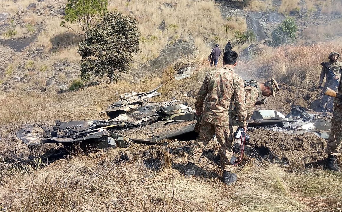 Pakistani soldiers stand next to what Pakistan says is the wreckage of an Indian fighter jet shot down in Pakistan-controlled Kashmiron on February 27th, 2019.