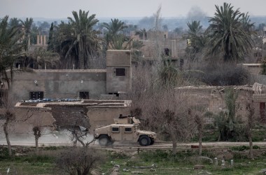 A Syrian Democratic Forces armored vehicle drives through streets near the frontline on February 10th, 2019, in Bagouz, Syria, as part of the SDF's campaign to oust ISIS fighters from the last village in eastern Syria held by the extremist group.