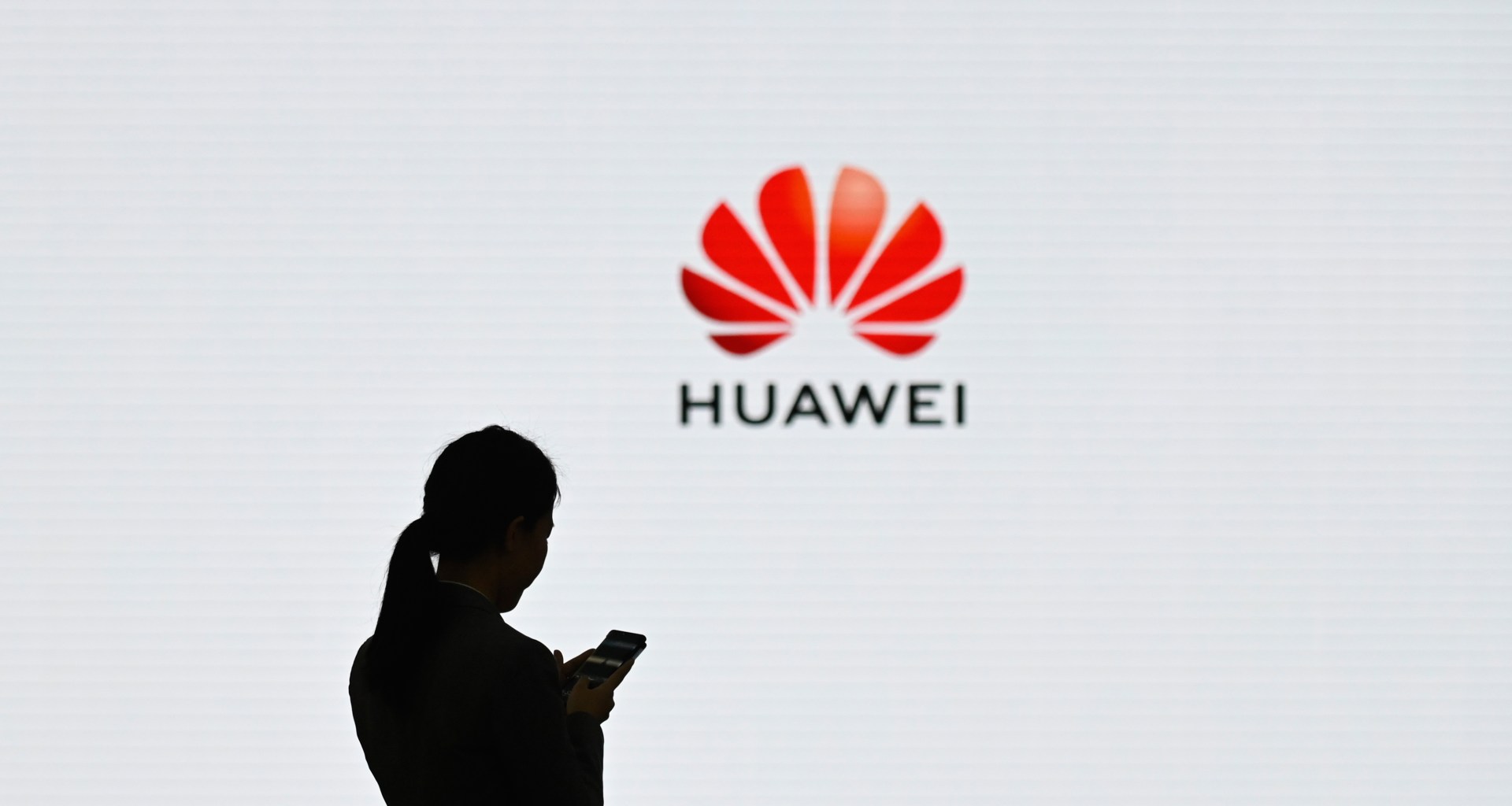 A staff member of Huawei uses her mobile phone at the Huawei Digital Transformation Showcase.