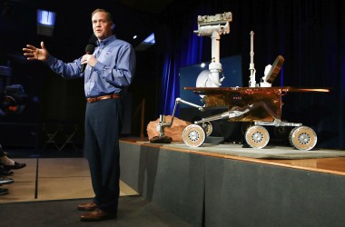 NASA Administrator Jim Bridenstine in front of a model of the Opportunity rover