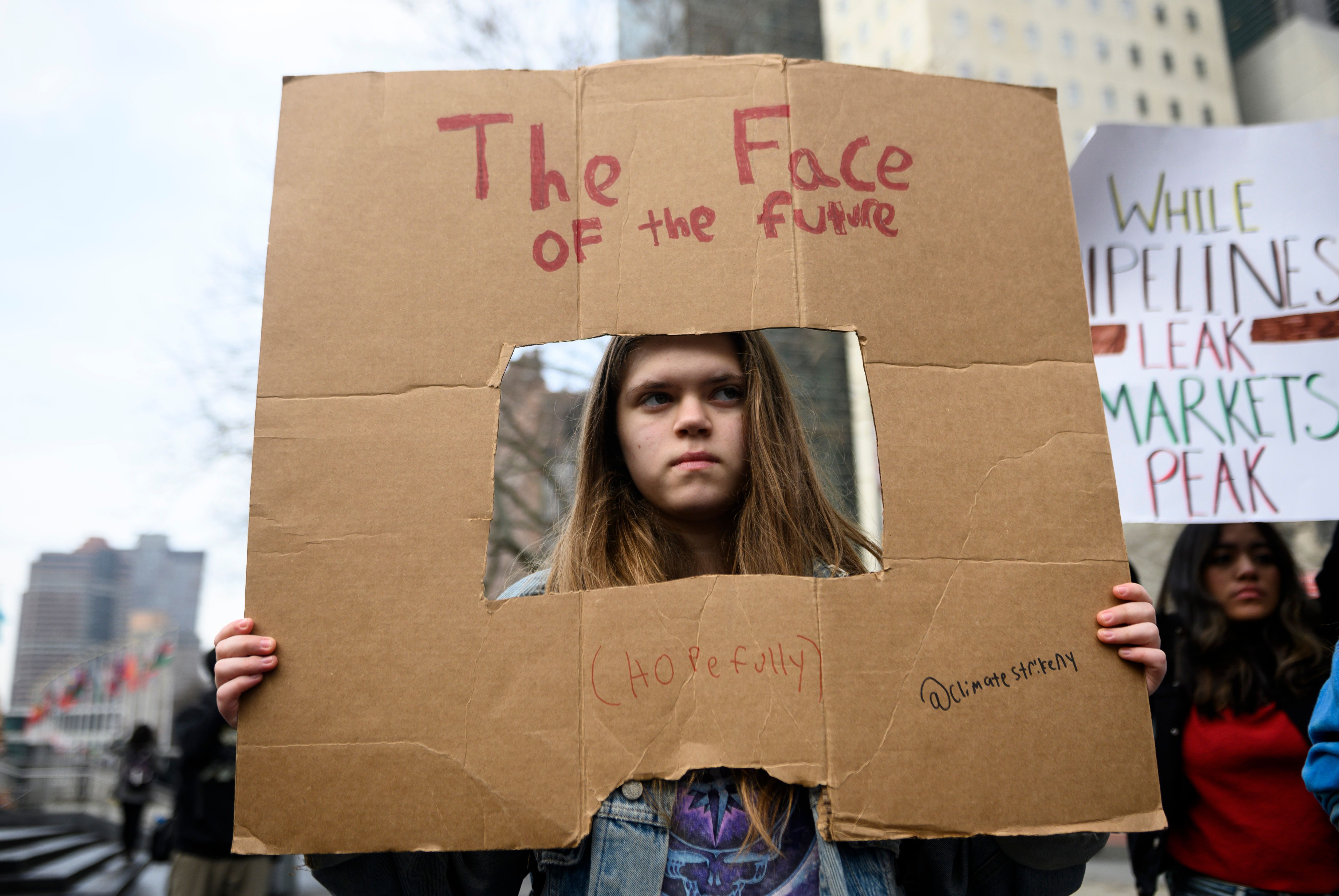 A girl holds a sign reading, 