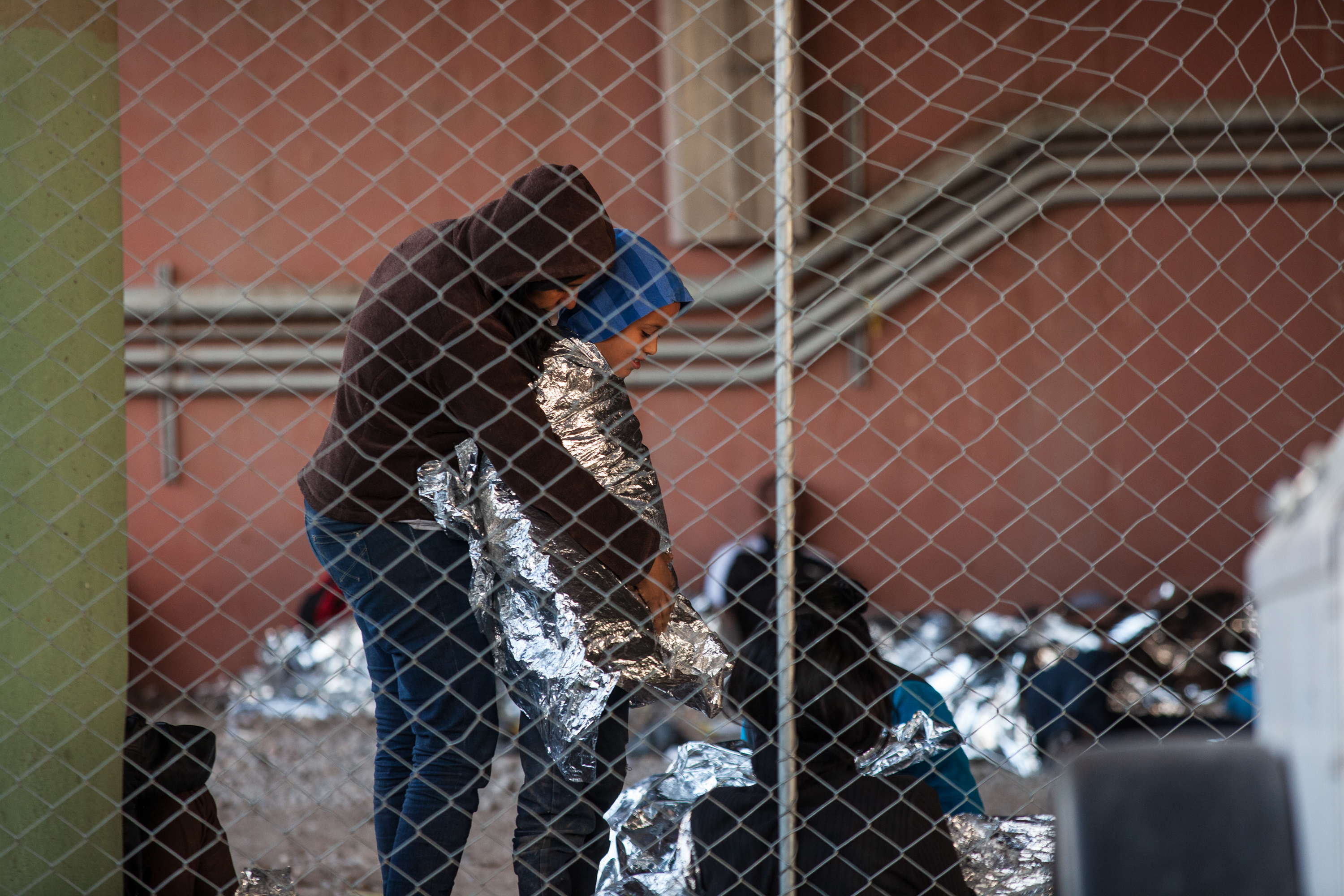 Children and families huddle against the cold wind. CBP provided mylar blankets.