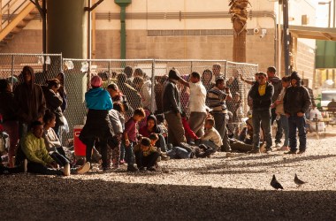 Migrants and asylum seekers awaiting processing are held in temporary fencing underneath the Paso Del Norte Bridge on March 28th, in El Paso, Texas. U.S. Customs and Border Protection has temporarily closed all highway checkpoints along the 268-mile stretch of border in the El Paso sector.