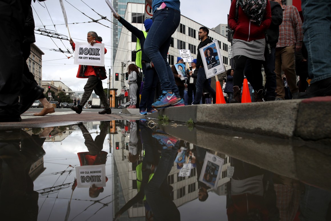 A San Francisco city worker holds a sign as workers march during a rally outside of the City and County of San Francisco Human Resources office on March 7th, 2019, in San Francisco, California. Hundreds of San Francisco city workers staged a rally to demand a fair contract that addresses pay equity for women.