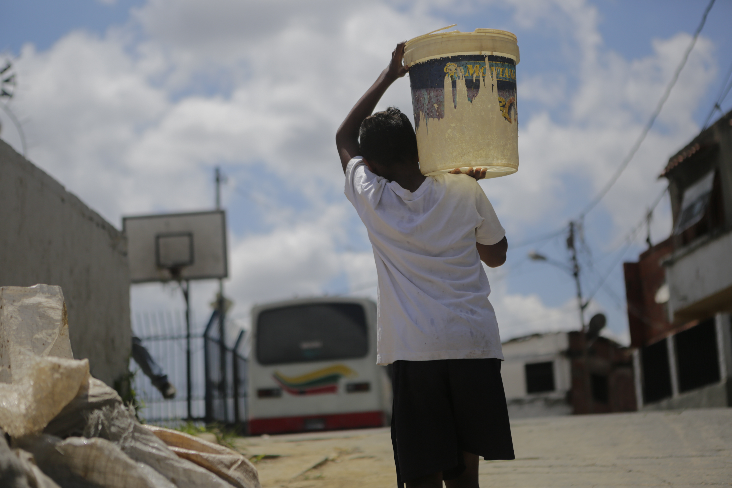 A child carries a container filled with water at the slum of Petare, on April 4th, 2019, in Caracas, Venezuela. Since March 7th, Venezuela has been suffering intermittent blackouts, which have affected the water supply. People have to collect water from waterfalls and pipes and carry it to their homes. This water, not always suitable for human consumption, is used for drinking, cooking, and bathing.