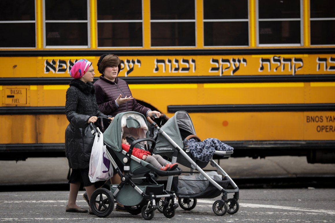 Women pushing strollers walk past the Yeshiva Kehilath Yakov School in the South Williamsburg neighborhood, on April 9th, 2019, in the Brooklyn borough of New York City.