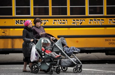 Women pushing strollers walk past the Yeshiva Kehilath Yakov School in the South Williamsburg neighborhood, on April 9th, 2019, in the Brooklyn borough of New York City.