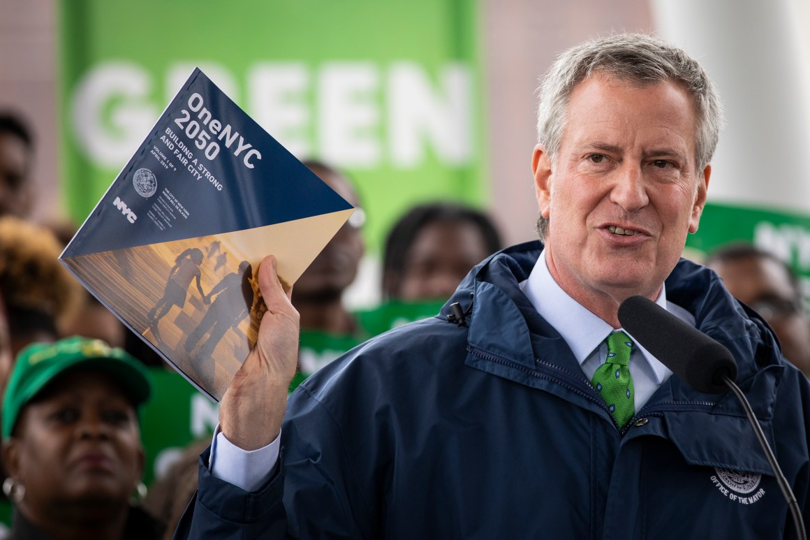 New York City Mayor Bill de Blasio holds up a copy of the One NYC 2050 plan as he speaks about the city's response to climate change at Hunter's Point South Park on April 22nd, 2019, in the Queens borough of New York City. The Climate Mobilization Act, which has been referred to as a Green New Deal for the city, passed the city council last Thursday. The legislation, which is part of a broader plan to reduce the city's carbon footprint, would require private building owners to cut their emissions by 40 percent by 2030. The One NYC 2050 report, released Monday, includes plans for how the city can meet that goal.