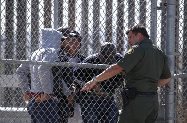 A U.S. Border Patrol agent talks with detained migrants at the border of the United States and Mexico on March 31st, 2019, in El Paso, Texas.