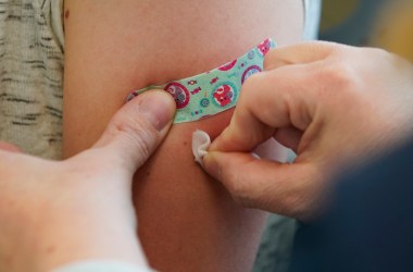 A nurse prepares an arm for vaccination.