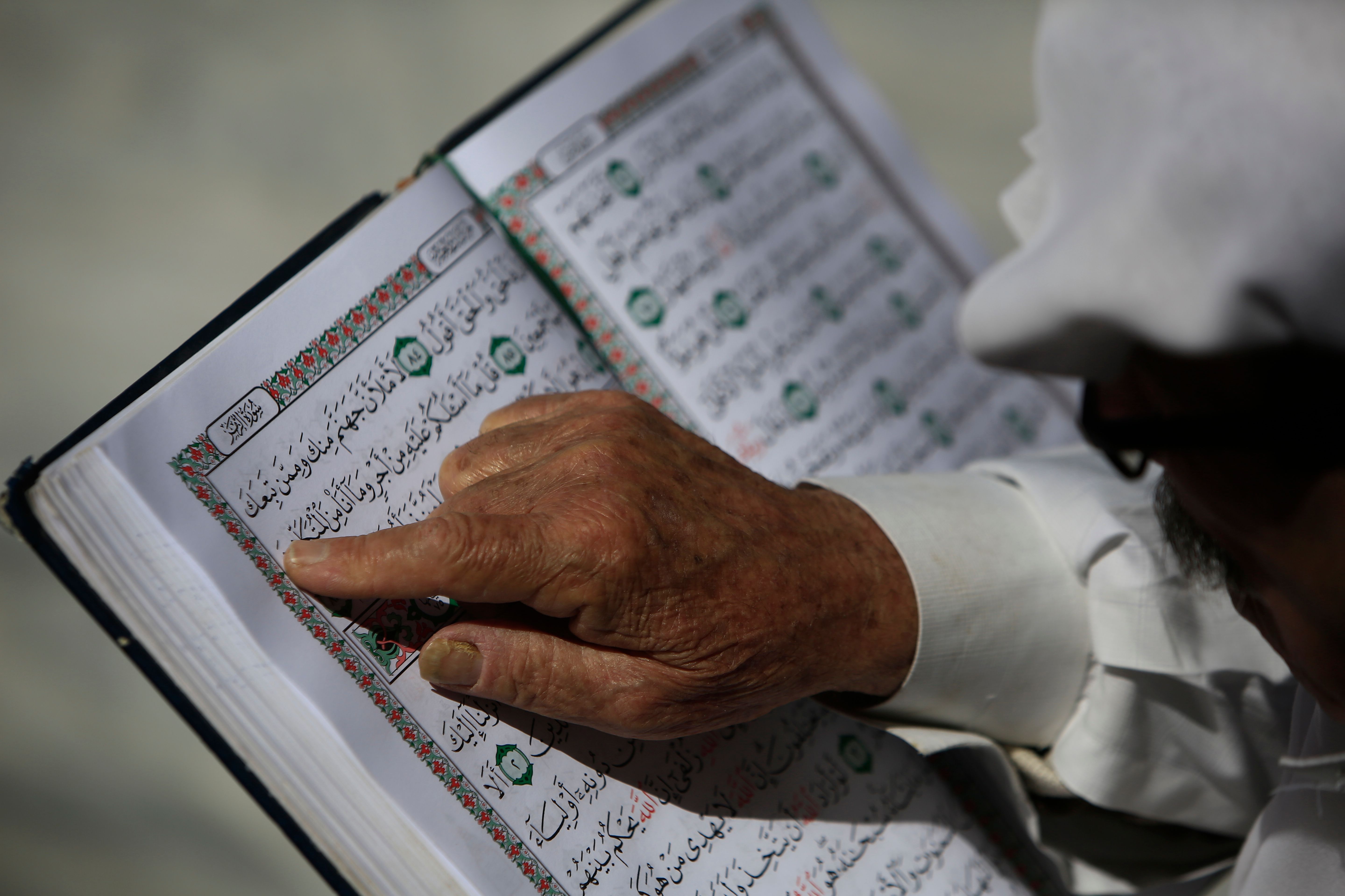 A Palestinian man reads the Quran at the al-Omari mosque in Gaza City, on the second day of Ramadan on May 7th, 2019.