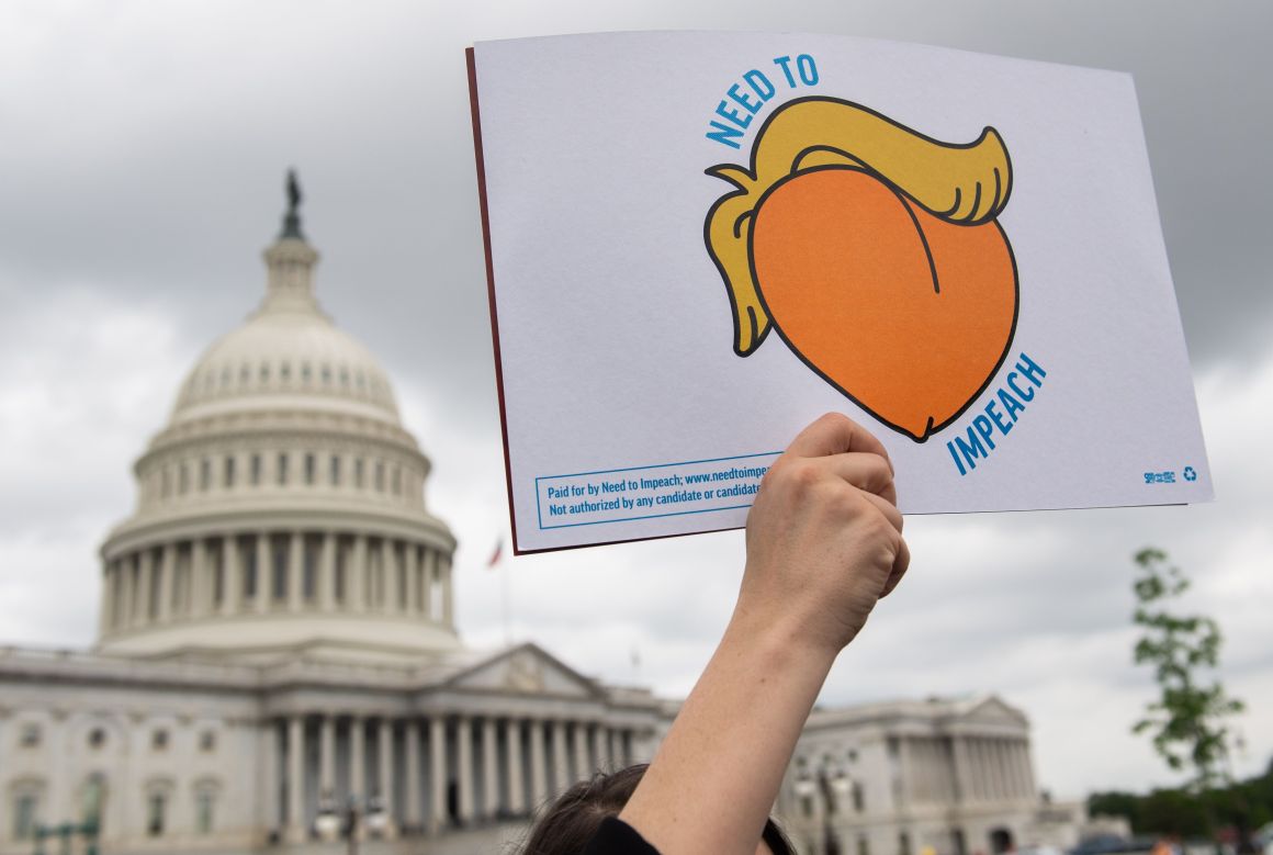 A woman holds a sign during a press conference where activists delivered a computer flash drive with 10 million signatures to lawmakers at the United States Capitol in Washington, D.C., on May 9th, 2019. The signatures were on a petition urging Congress to begin impeachment proceedings against President Donald Trump.