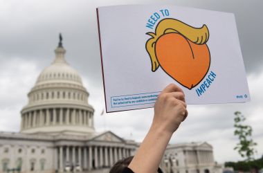 A woman holds a sign during a press conference where activists delivered a computer flash drive with 10 million signatures to lawmakers at the United States Capitol in Washington, D.C., on May 9th, 2019. The signatures were on a petition urging Congress to begin impeachment proceedings against President Donald Trump.