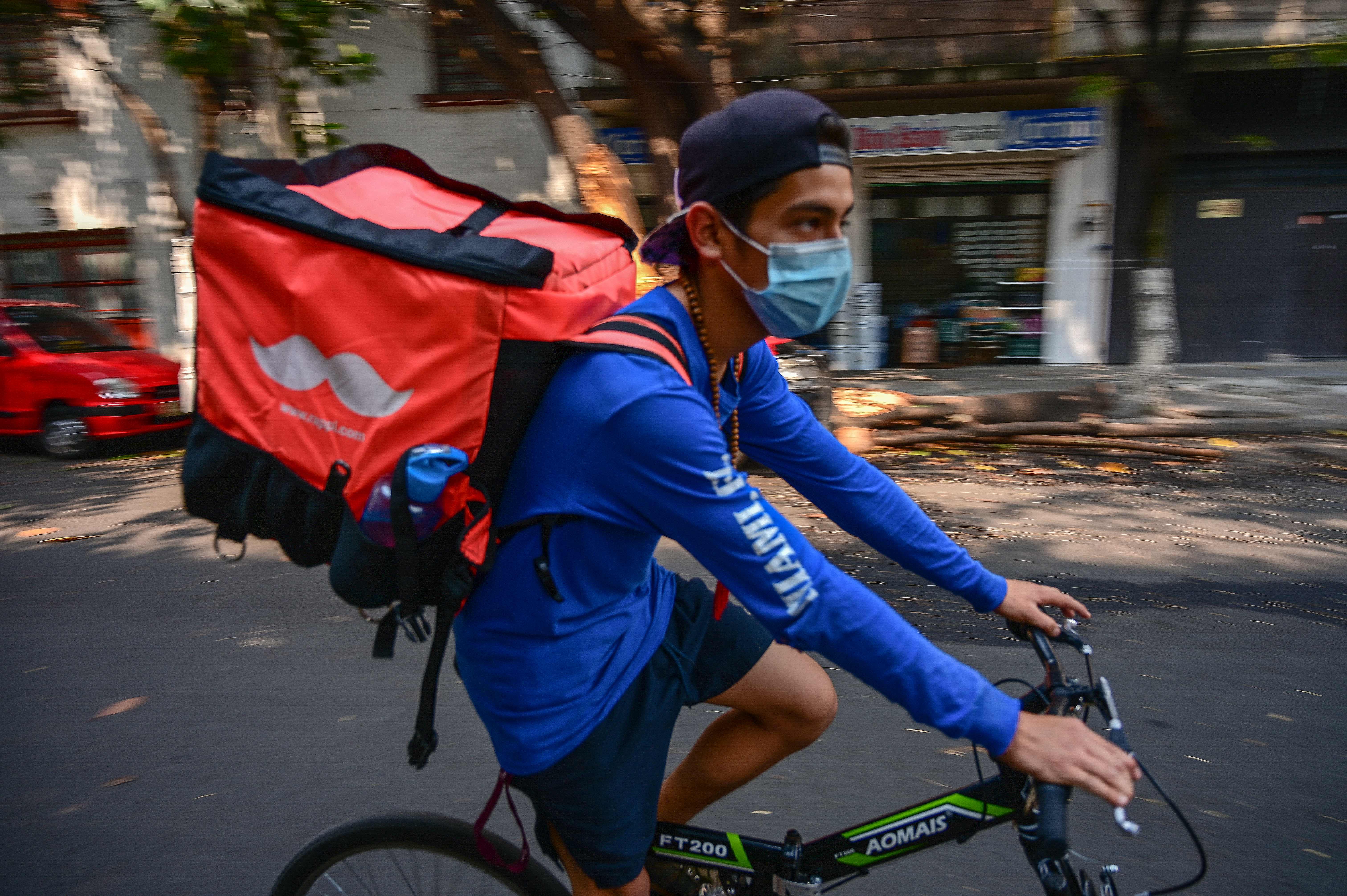 A boy working as a food deliverer wears a face mask in Mexico City, on May 16th, 2019.