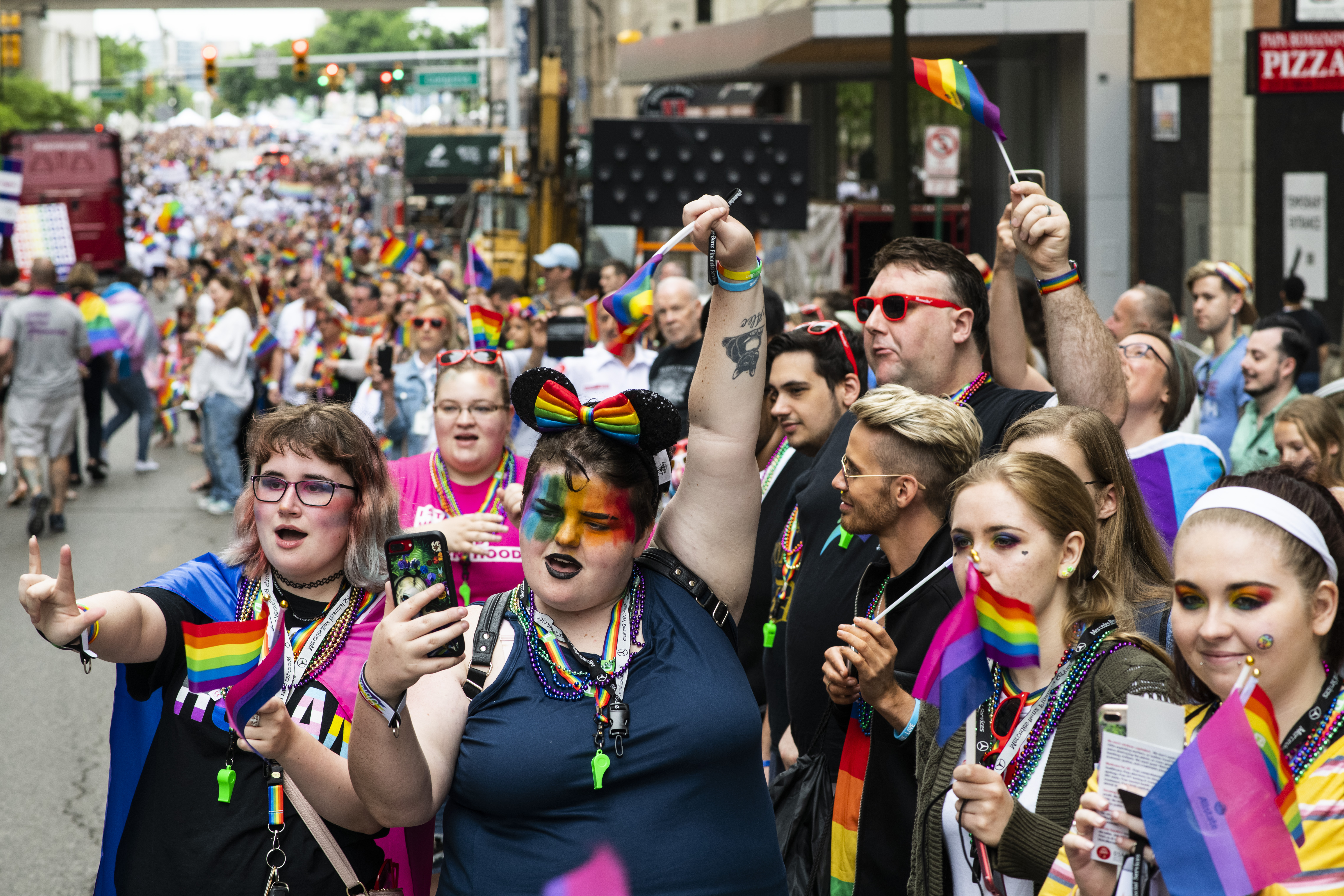 Locals and onlookers shout and wave rainbow flags during the Motor City Pride Parade on June 9th, 2019, in Detroit, Michigan.