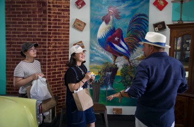 Hengshan Hao and Dengyumei Du, originally from China, listen to Fidel Asis Lopez as they visit the Little Havana neighborhood on May 28th, 2019, in Miami, Florida.